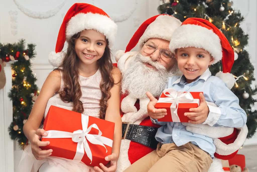 Santa with 2 children holding presents.
