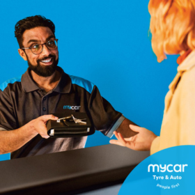 Male mycar employee handing keys to female customer.