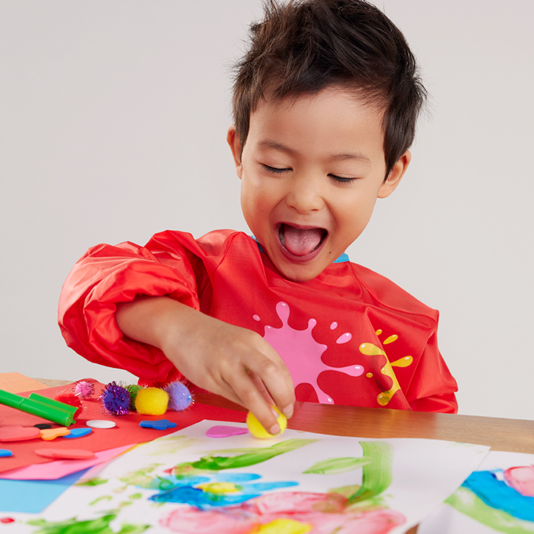 Child drawing pictures and laughing