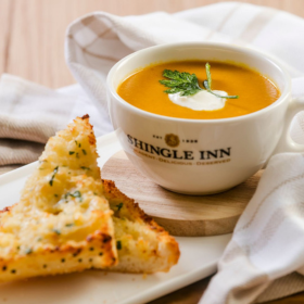 Bowl of pumpkin soup and side of garlic bread