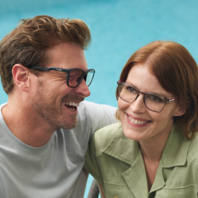 Man and Woman smiling, wearing glasses.